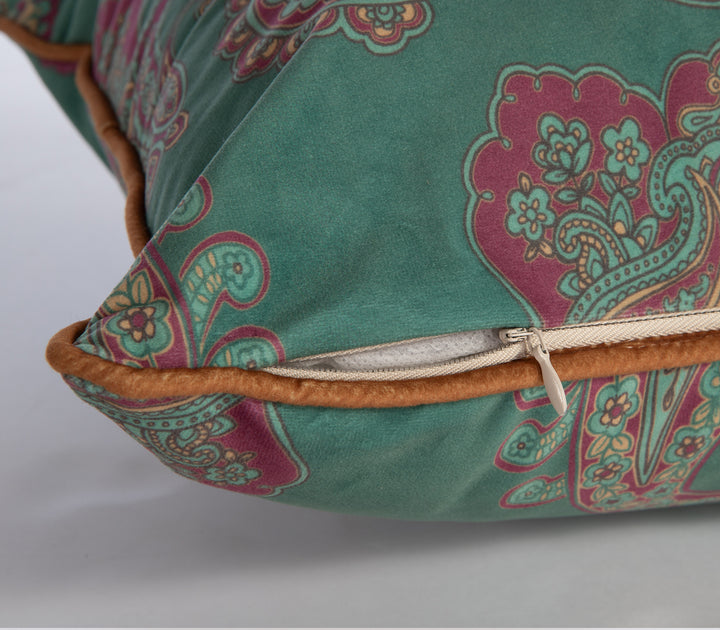 Κοντινό σε πράσινο μαξιλάρι με boho paisley σχέδιο σε κόκκινο και μουσταρδί, με καφέ ρέλι και κρυφό φερμουάρ.