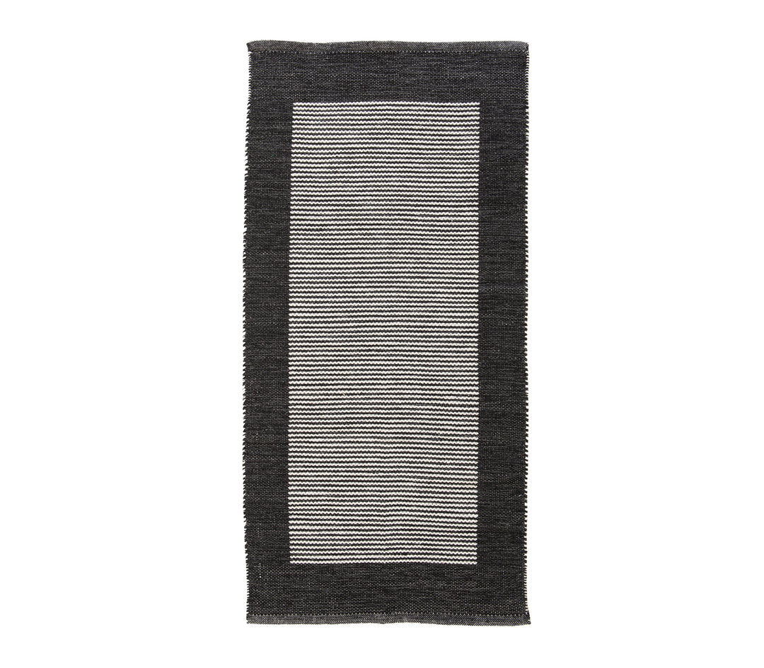 Μαύρο χαλί με λευκές ρίγες και πλαίσιο περιμετρικά, σε λευκό φόντο.