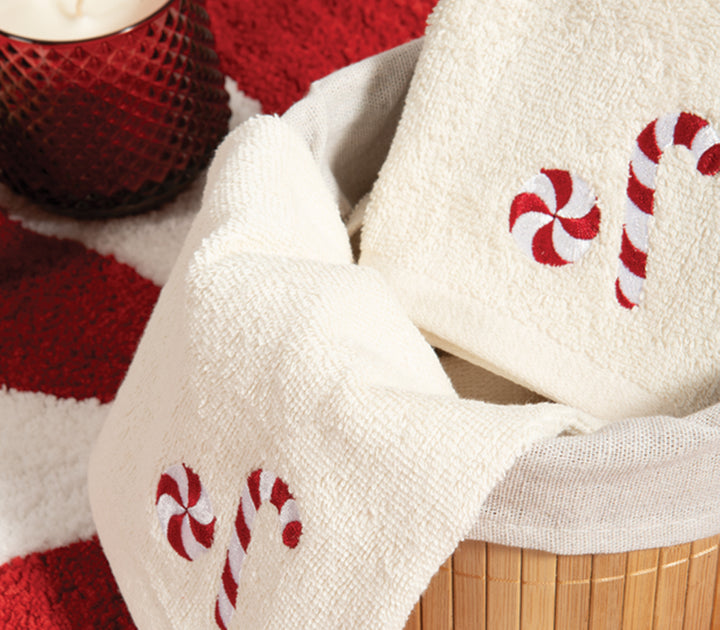 Κοντινό πλάνο πετσετών σε εκρού χρώμα με κεντημένα σχέδια candy cane και κόκκινα διακοσμητικά στοιχεία, της εταιρείας Nef Nef Homeware.