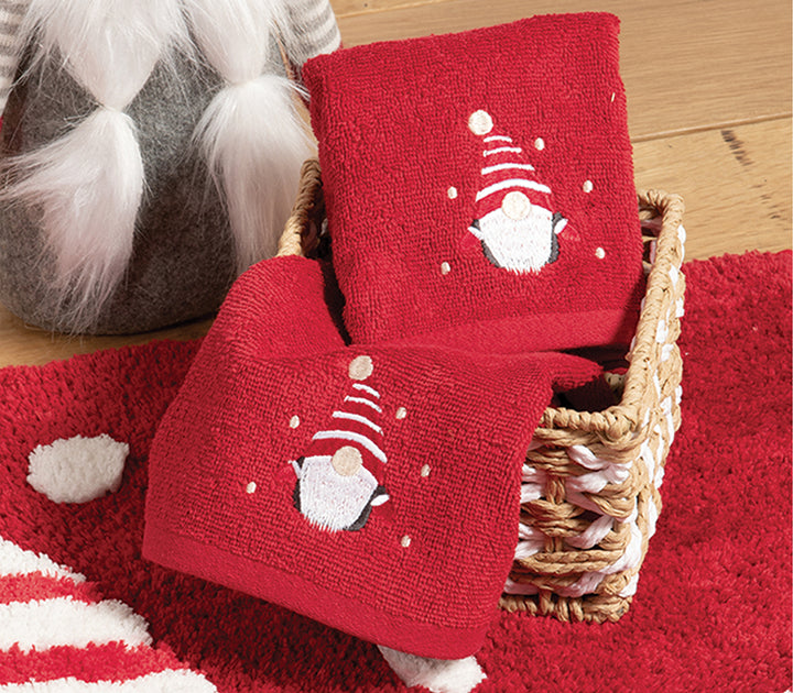 Κοντινό πλάνο κόκκινων πετσετών με χριστουγεννιάτικο σχέδιο νάνου και λεπτομέρειες σε λευκό, της εταιρείας Nef Nef Homeware.