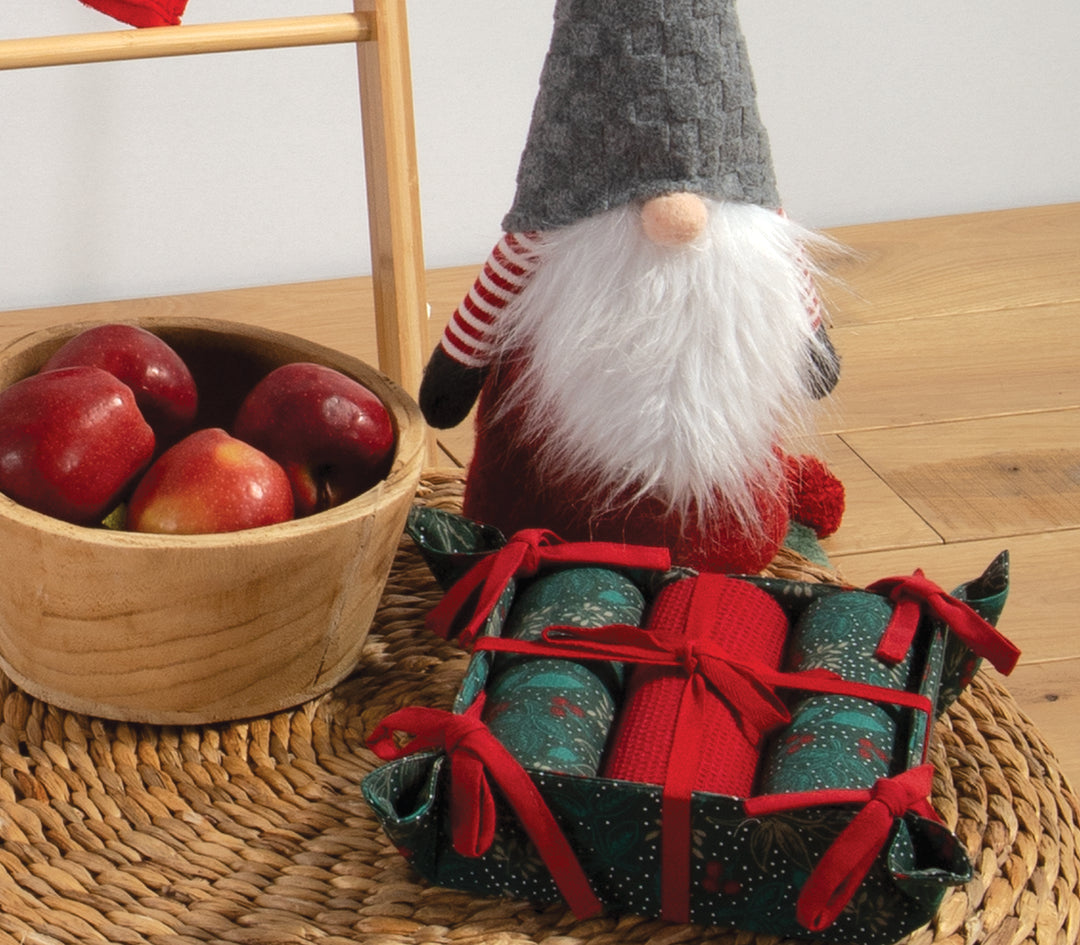 Χριστουγεννιάτικο καλάθι με σετ τριών ποτηρόπανων σε αποχρώσεις πράσινου και κόκκινου, δεμένα με κορδέλες, σε γιορτινό σχέδιο με μοτίβα φύλλων