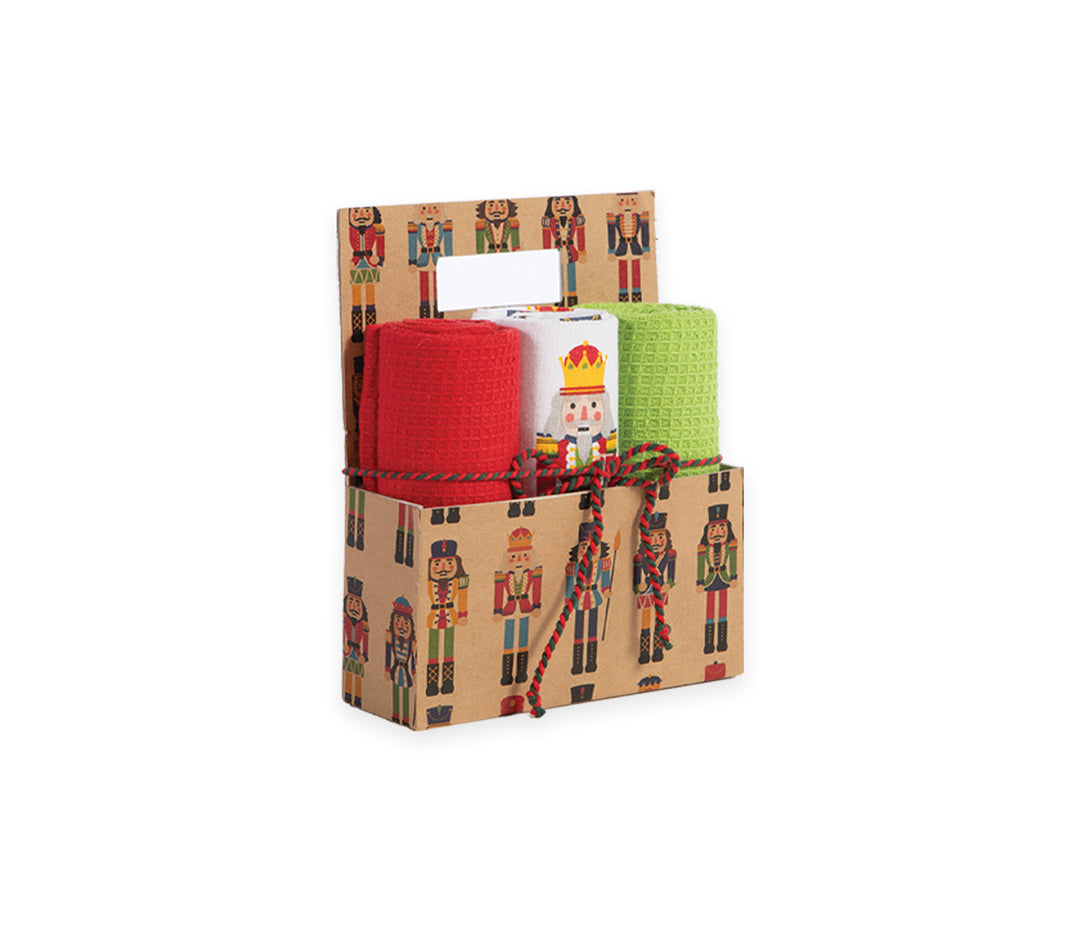 Χριστουγεννιάτικο καλάθι δώρου με τρία ποτηρόπανα σε κόκκινο, λευκό και πράσινο χρώμα, τοποθετημένα σε διακοσμητικό κουτί με σχέδιο καρυοθραύστες και δεμένο με κόκκινο-πράσινο κορδόνι.