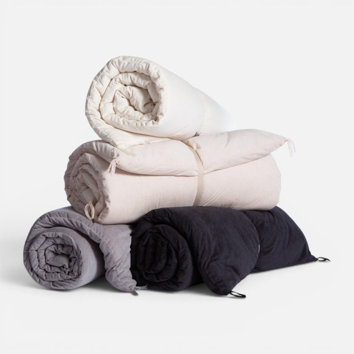 Ανωστρώματα καναπέ Eriete Nef-Nef Homeware τυλιγμένα και στοιβαγμένα σε μπεζ, εκρού, γκρι και ανθρακί αποχρώσεις.
