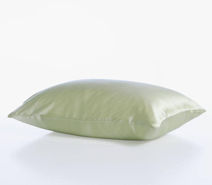 Μεταξωτή μαξιλαροθήκη σε πράσινη απόχρωση με λεία γυαλιστερή υφή τοποθετημένη σε καθαρό λευκό φόντο.