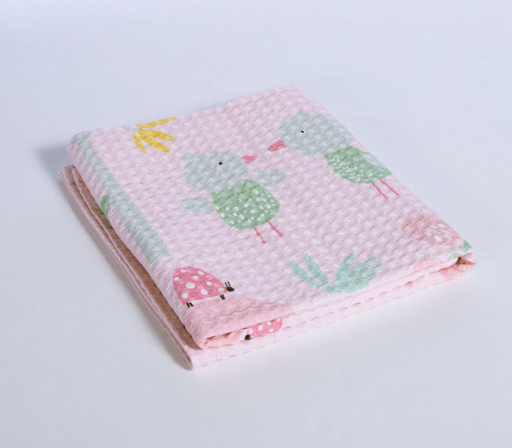 Ροζ βρεφική κουβέρτα πικέ με παιδικά σχέδια πουλιών, λουλουδιών και ήλιου σε λευκό φόντο.