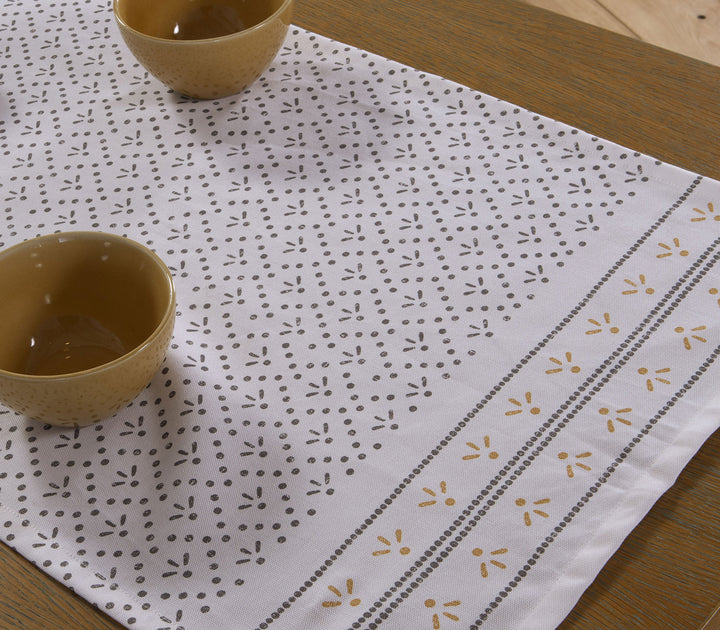 Εκρού βαμβακερή τραβέρσα Ishmar της Nef-Nef Homeware με διακριτικό μαύρο μοτίβο και μπολ σε ξύλινο τραπέζι.