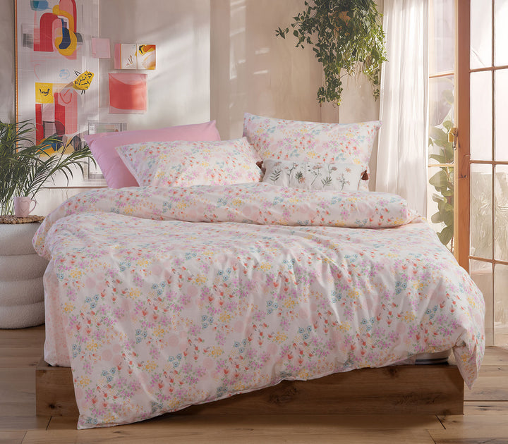 Ροζ παιδικό σετ σεντονιών Blossom Day της Nef-Nef Homeware με πολύχρωμα λουλούδια σε φωτεινό παιδικό υπνοδωμάτιο.