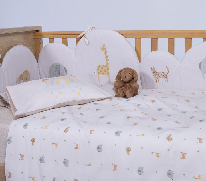 Κοντινό σε βρεφικό σετ σεντονιών κούνιας με σχέδια ζώων ζούγκλας και μαξιλαροθήκη με ουράνιο τόξο.