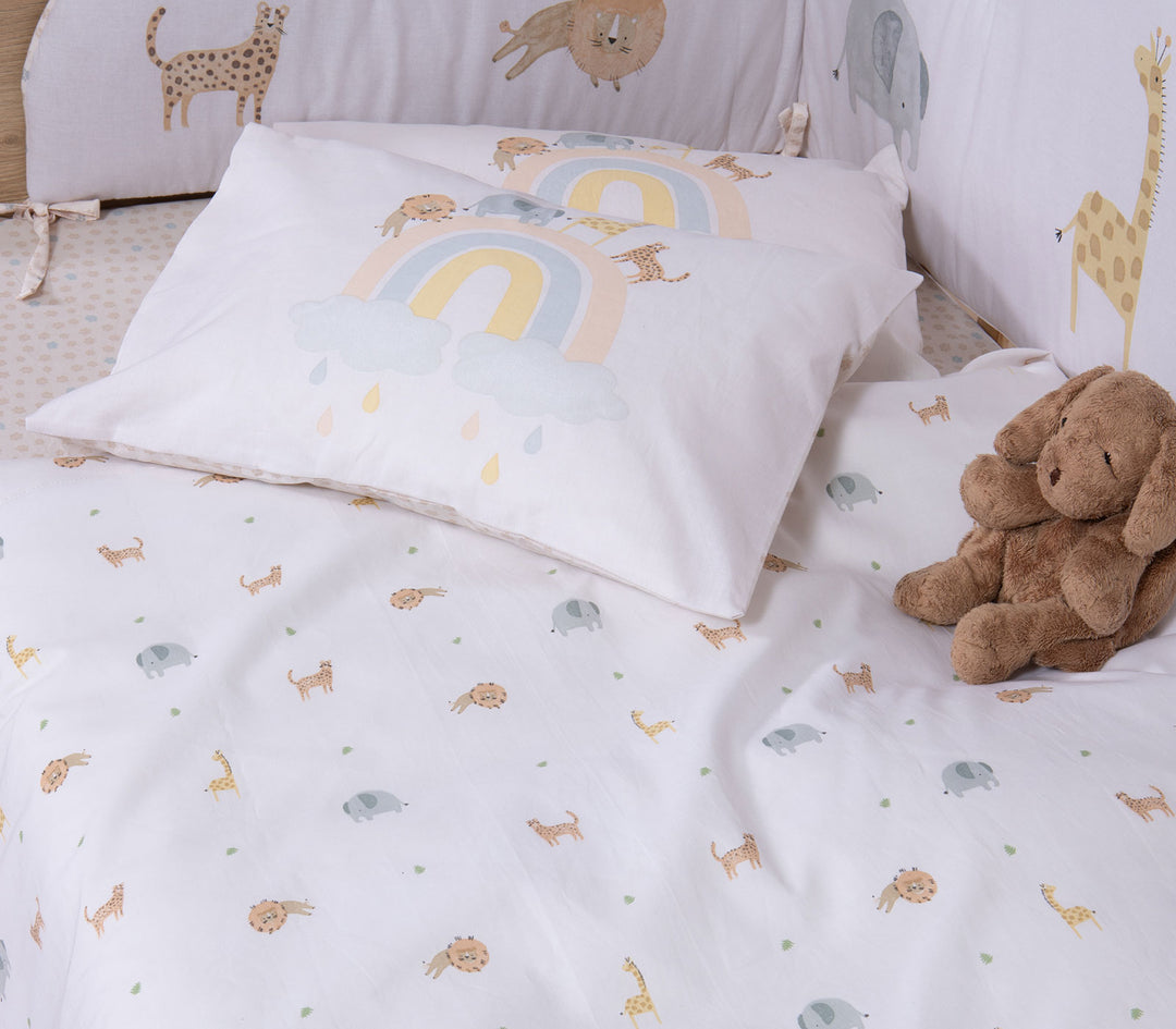 Βρεφικό σετ σεντονιών κούνιας με ζωάκια ζούγκλας και μαξιλαροθήκη με ουράνιο τόξο τοποθετημένο σε βρεφική κούνια.