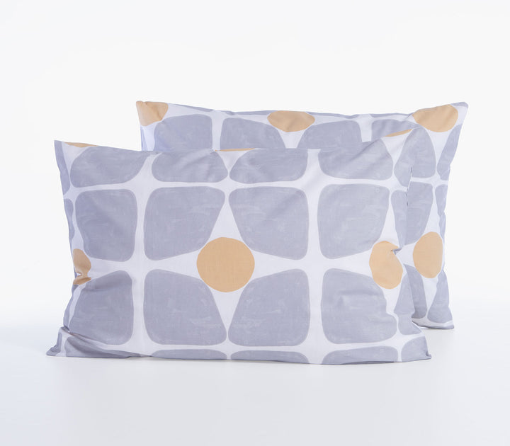 Δύο βαμβακερές μαξιλαροθήκες ύπνου σε γκρι και κίτρινες αποχρώσεις με γεωμετρικό μοτίβο σε λευκό φόντο.