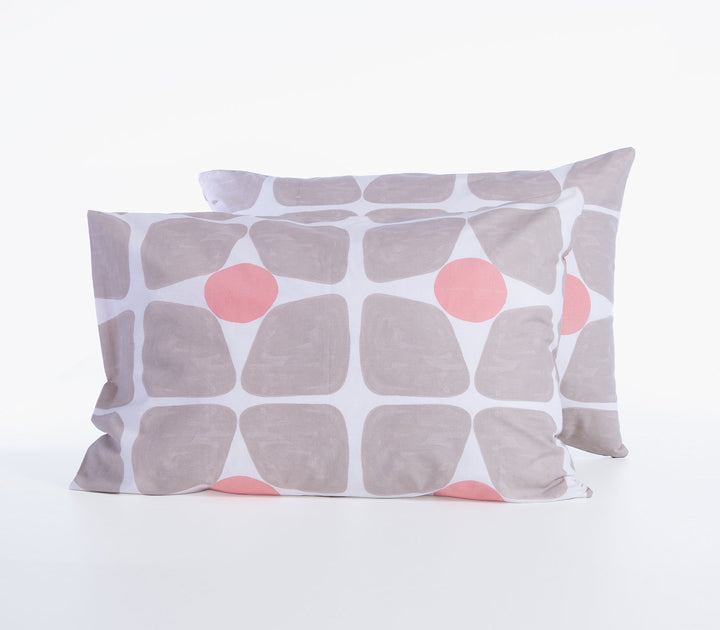 Δύο βαμβακερές μαξιλαροθήκες ύπνου σε μπεζ και κοραλλί αποχρώσεις με γεωμετρικό μοτίβο σε λευκό φόντο.