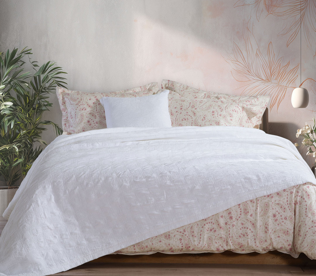 Λευκή βαμβακερή κουβέρτα Nef-Nef Homeware στρωμένη σε κρεβάτι με floral σεντόνια σε φωτεινό και ζεστό υπνοδωμάτιο.