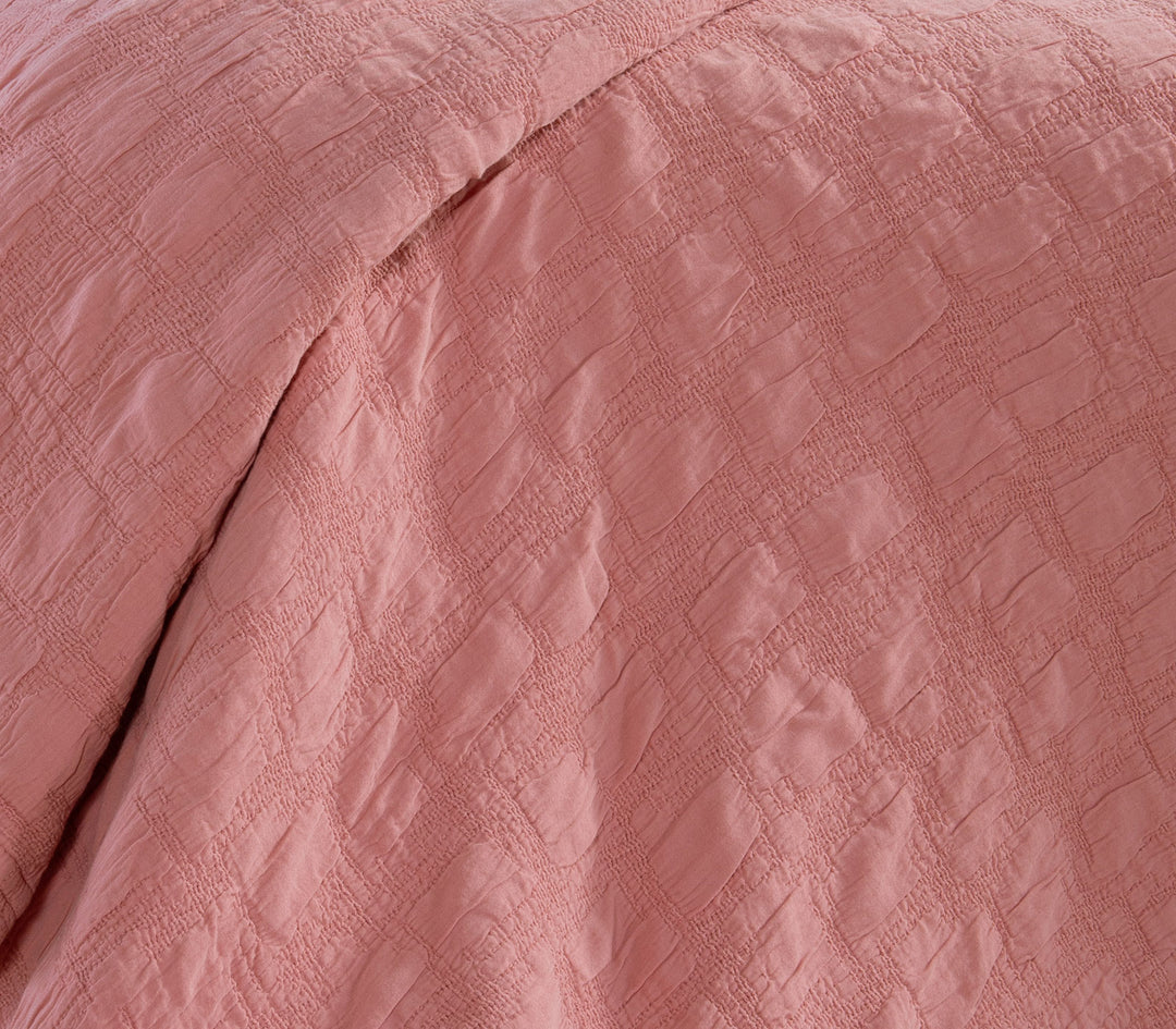 Κοντινή λήψη βαμβακερής κουβέρτας Nef-Nef Homeware σε κοραλί χρώμα που αναδεικνύει τη ζακάρ υφή του υφάσματος.