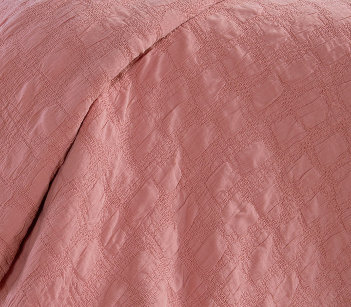 Κοντινή λήψη βαμβακερής κουβέρτας Nef-Nef Homeware σε κοραλί χρώμα που αναδεικνύει τη ζακάρ υφή του υφάσματος.