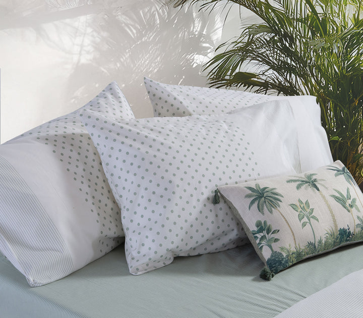 Μαξιλαροθήκες ύπνου Nef-Nef Homeware με πουά μοτίβο τοποθετημένες σε στρωμένο κρεβάτι με πράσινο σεντόνι.