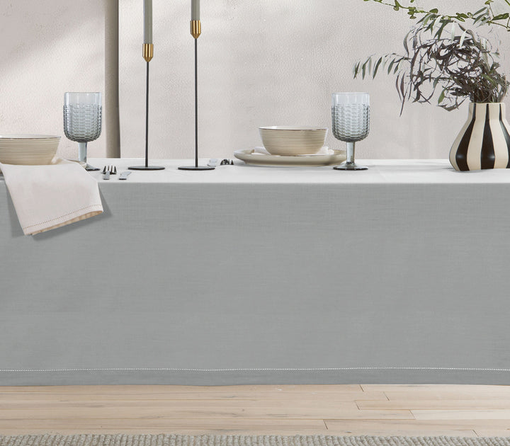 Γκρι βαμβακερό τραπεζομάντηλο σε στρωμένο τραπέζι με πιάτα, ποτήρια και μοντέρνα διακοσμητικά στοιχεία.