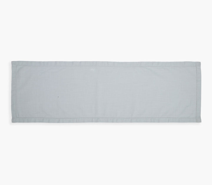 Γκρι μονόχρωμη βαμβακερή τραβέρσα σε ουδέτερο φόντο με απλή υφή και καθαρές γραμμές σχεδιασμού.