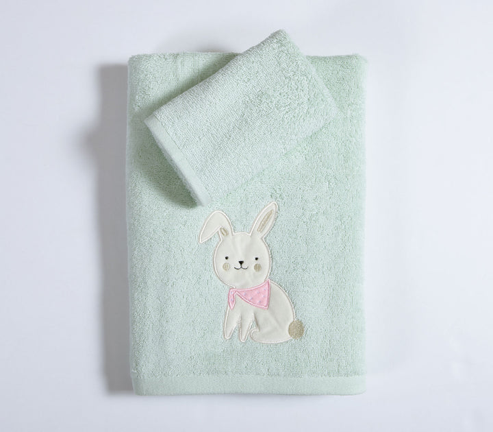 Διπλωμένες βρεφικές πετσέτες πράσινες με σχέδιο λαγουδάκι σε καθαρό λευκό φόντο φωτογράφισης.