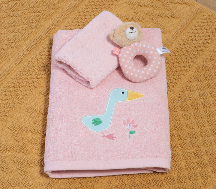 Ροζ βρεφικές πετσέτες διπλωμένες με κεντημένο παπάκι και μικρό παιχνίδι πάνω σε υφασμάτινο χαλί.