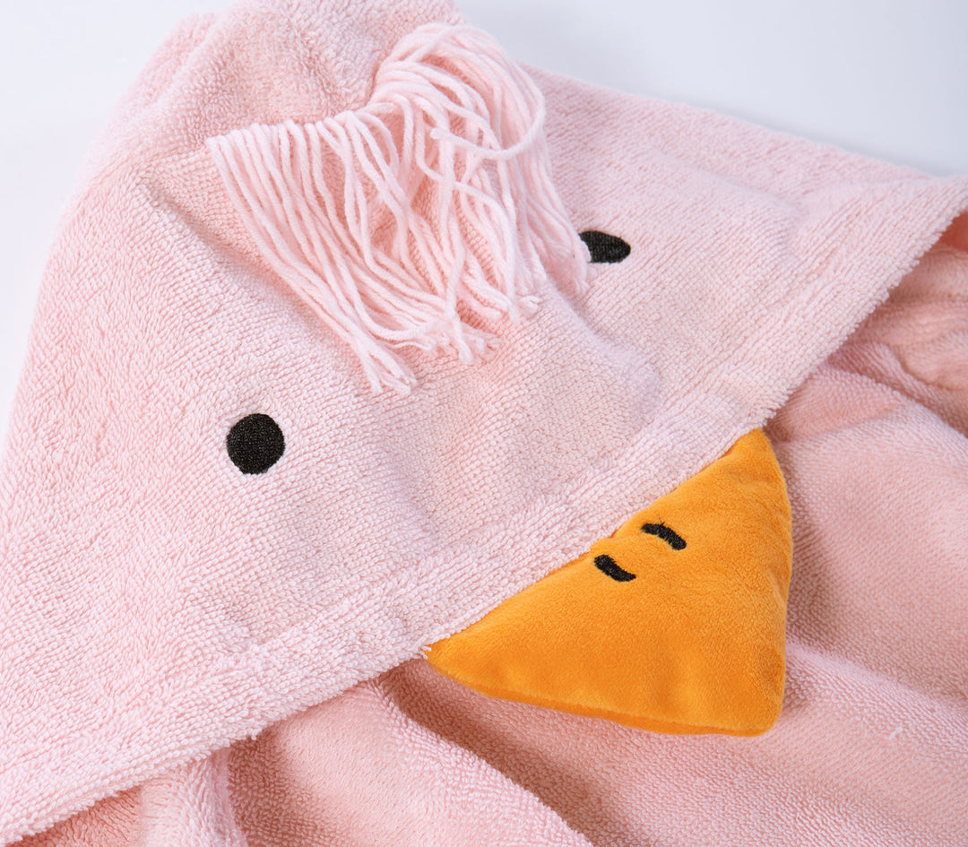 Κοντινό πλάνο ροζ βρεφικής κάπας μπάνιου με κουκούλα παπάκι και πορτοκαλί ράμφος.