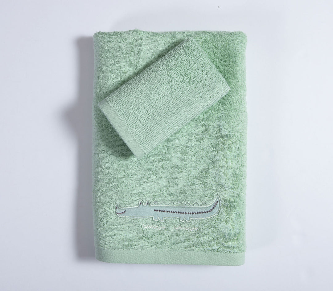 Σετ βρεφικές πετσέτες πράσινες διπλωμένες με κεντημένο κροκόδειλο σε καθαρό λευκό φόντο φωτογράφισης.