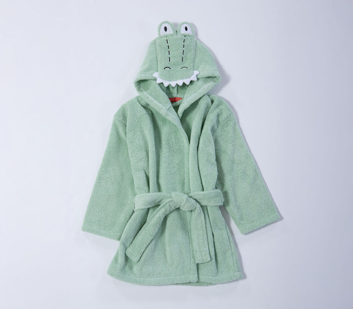 Βρεφικό μπουρνούζι πράσινο με κουκούλα και χαριτωμένο σχέδιο κροκόδειλου σε καθαρό λευκό φόντο φωτογράφισης.