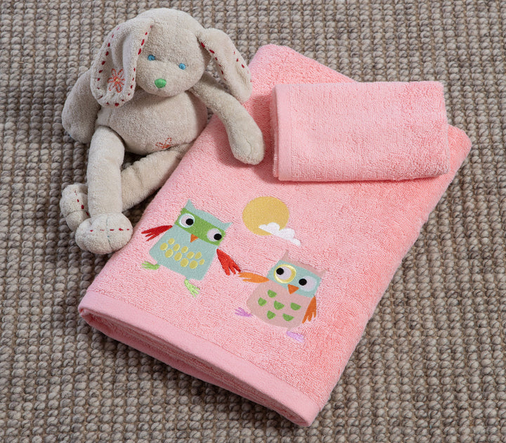 Σετ παιδικές ροζ πετσέτες Birds Mania της Nef-Nef Homeware με πολύχρωμες κουκουβάγιες και λούτρινο παιχνίδι πάνω σε ψάθινο χαλί.
