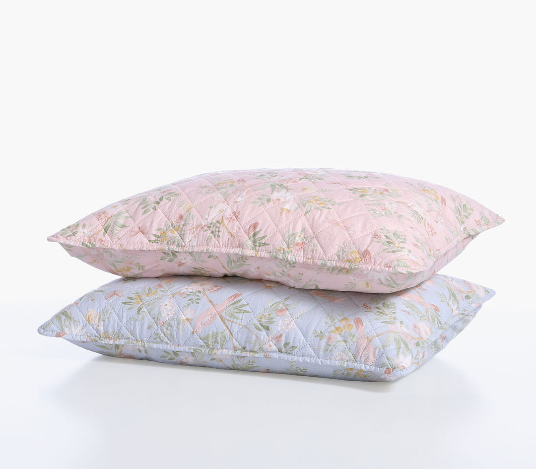 Δύο διακοσμητικές μαξιλαροθήκες Dreamel σε ροζ και γαλάζια απόχρωση με φλοράλ μοτίβο τοποθετημένες η μία πάνω στην άλλη.
