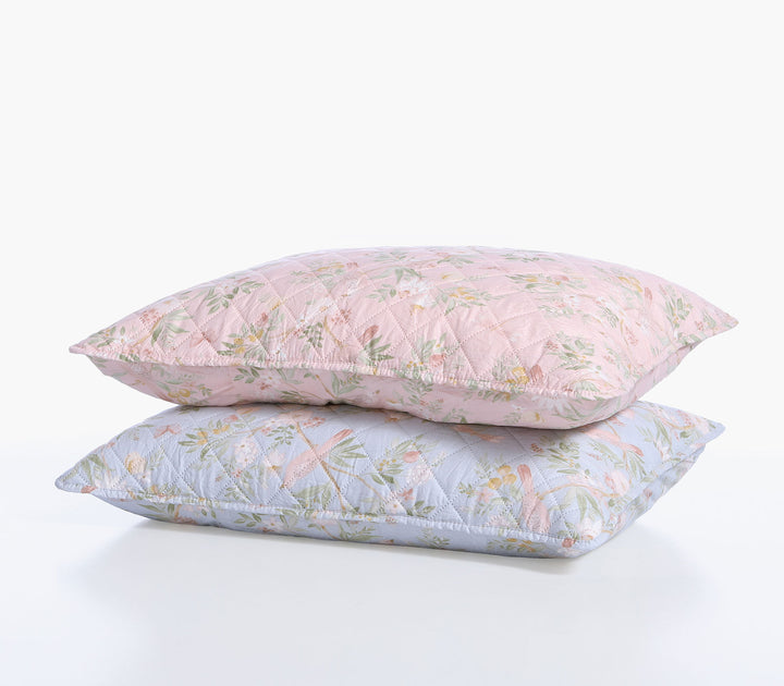 Δύο διακοσμητικές μαξιλαροθήκες Dreamel σε ροζ και γαλάζια απόχρωση με φλοράλ μοτίβο τοποθετημένες η μία πάνω στην άλλη.