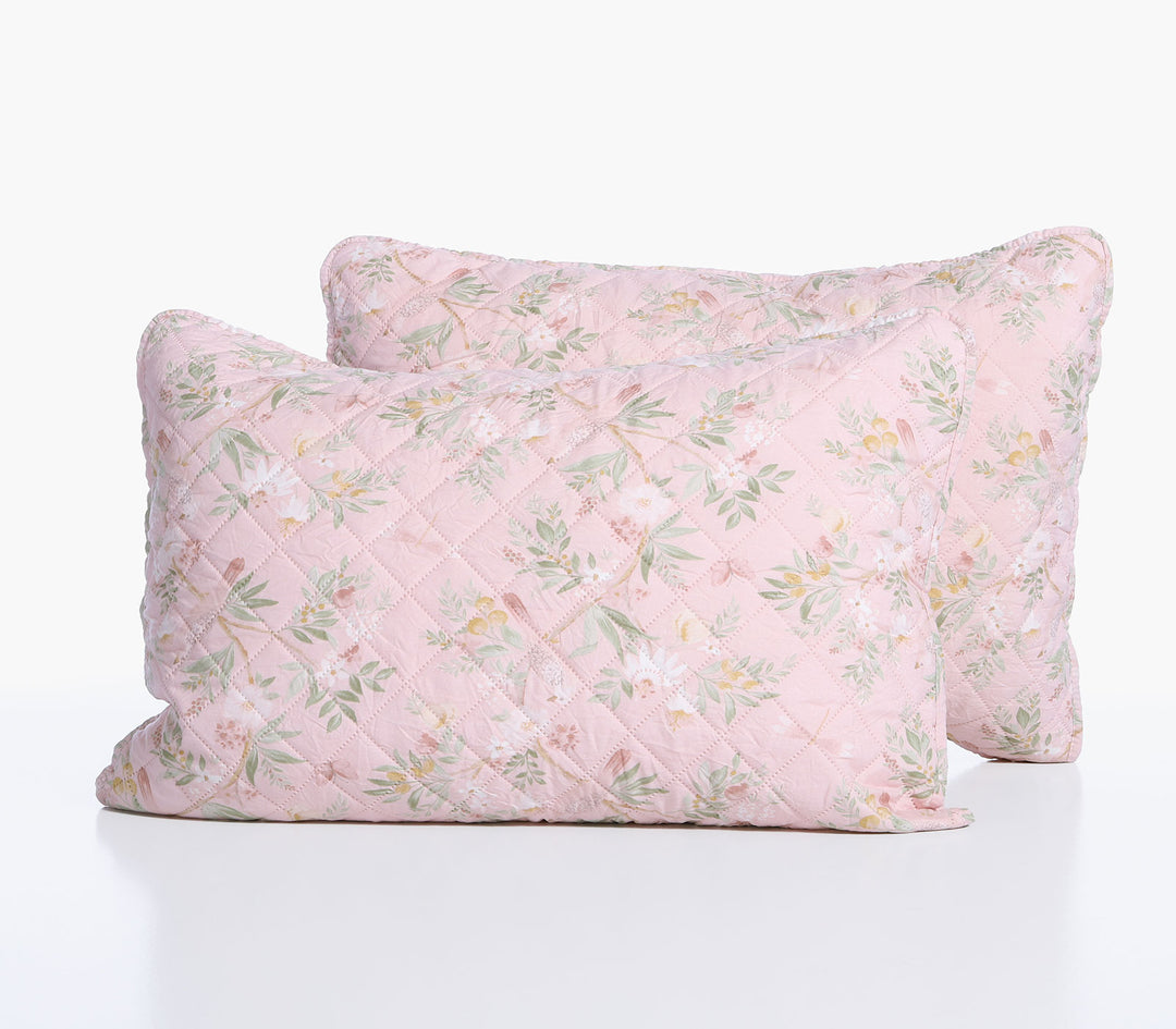Δύο ροζ διακοσμητικές μαξιλαροθήκες Dreamel με καπιτονέ ραφή και λουλουδάτο μοτίβο σε λευκό φόντο.