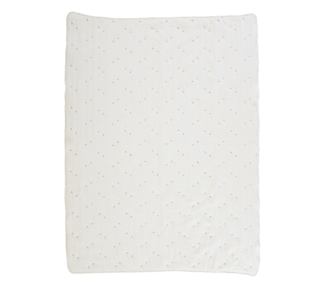 Εκρού βρεφικό κουβερλί με μικρά ροζ κεντημένα λουλουδάκια απλωμένο σε λευκό φόντο.