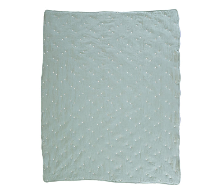 Μέντα βρεφικό κουβερλί απλωμένο σε λευκό φόντο με διάσπαρτα μικρά κεντημένα αστέρια.