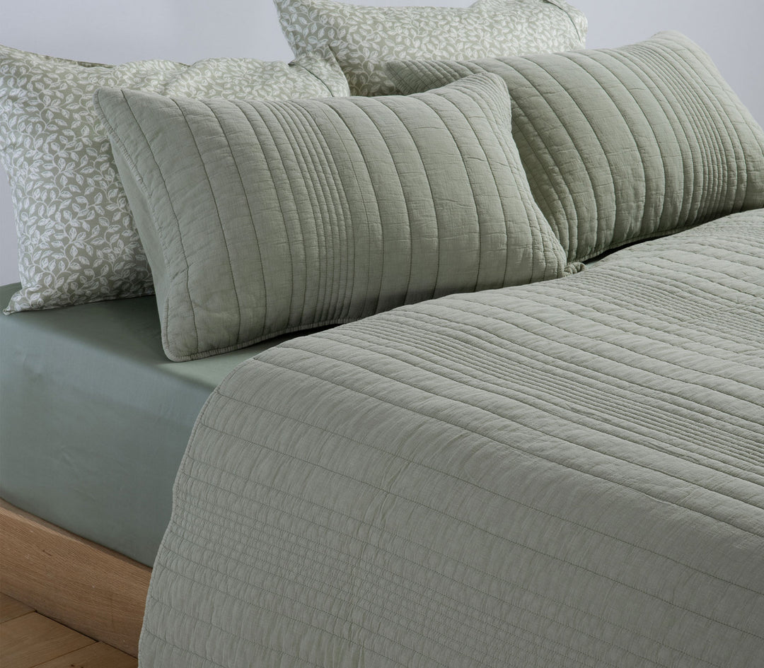 Πράσινο καπιτονέ κουβερλί Nef-Nef Homeware στρωμένο σε κρεβάτι με διακοσμητικά μαξιλάρια και απαλά πράσινα σεντόνια.
