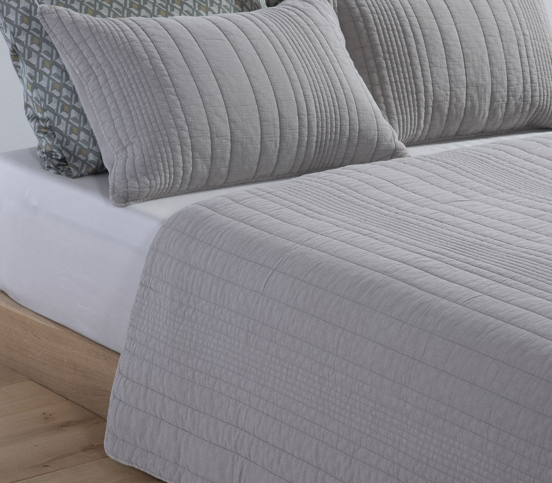 Διπλωμένο κουβερλί Nef-Nef Homeware σε μπλε απόχρωση με καπιτονέ υφή και ομοιόμορφες ραφές πάνω σε λευκό φόντο.