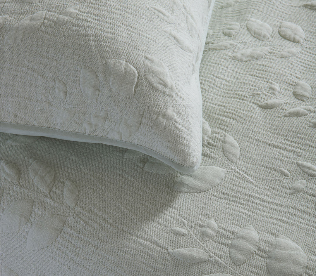 Κοντινό πλάνο υφής μαξιλαροθήκης με ανάγλυφο σχέδιο φύλλων.