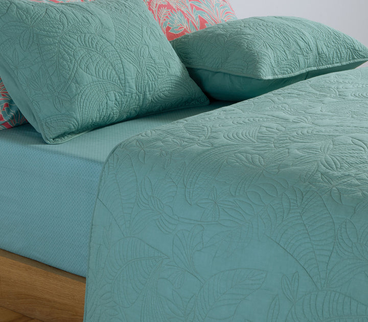 Κρεβάτι με πράσινο καπιτονέ κουβερλί Nef-Nef Homeware και μαξιλάρια στο ίδιο ύφος πάνω σε απαλό πράσινο σεντόνι.