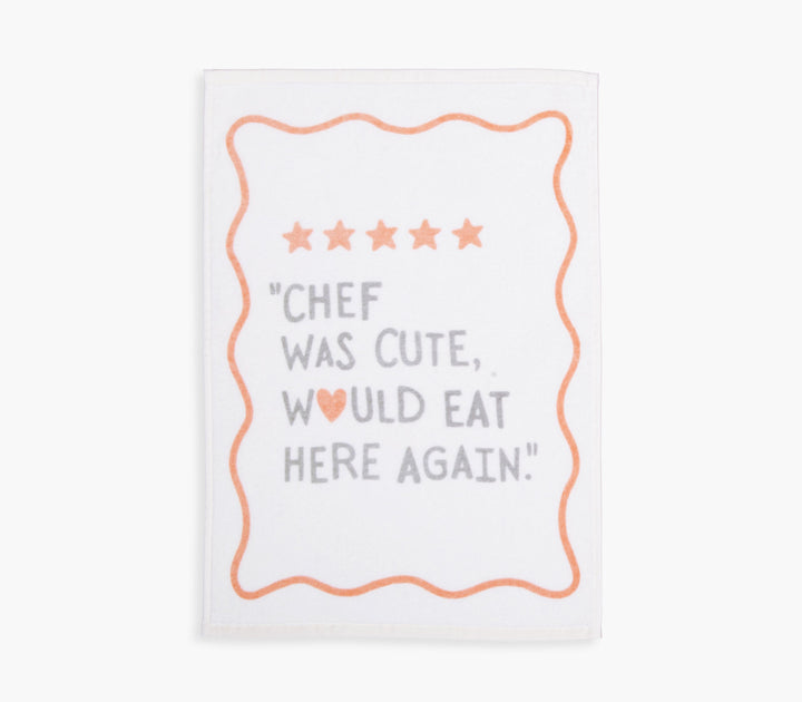 Ποτηρόπανο εκρού με πορτοκαλί λεπτομέρειες και διακοσμητικό μήνυμα σε minimal αισθητική.