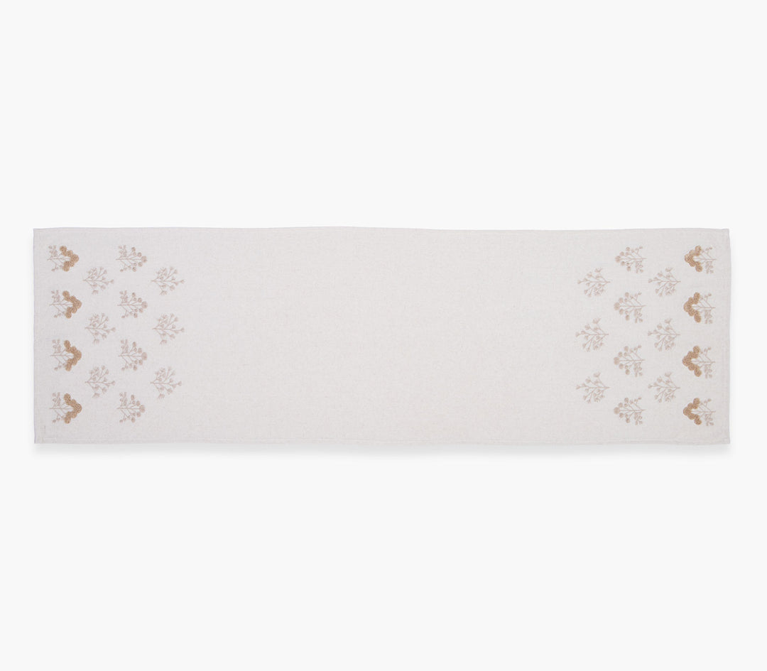 Μακριά τραβέρσα σε μπεζ απόχρωση με επαναλαμβανόμενο φυτικό μοτίβο στις άκρες σε καθαρό λευκό φόντο.