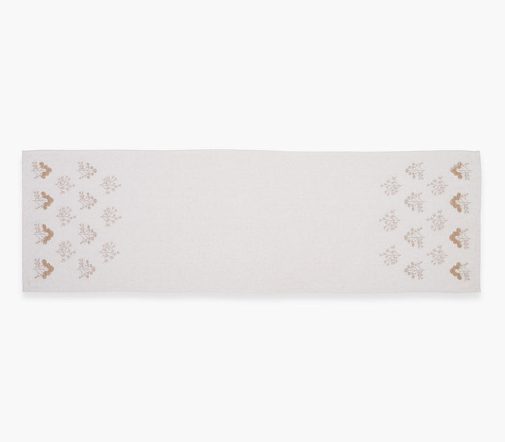 Μακριά τραβέρσα σε μπεζ απόχρωση με επαναλαμβανόμενο φυτικό μοτίβο στις άκρες σε καθαρό λευκό φόντο.