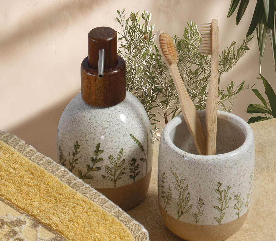 Μπεζ κεραμικό δοχείο κρεμοσάπουνου Bonjai με ξύλινη αντλία δίπλα σε ποτήρι μπάνιου και οδοντόβουρτσες σε φυσικό σκηνικό μπάνιου.