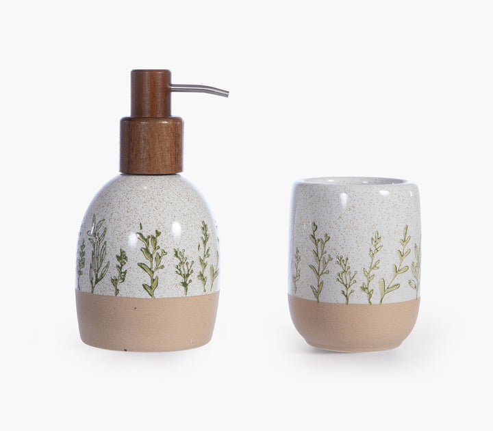 Μπεζ κεραμικό σετ μπάνιου Bonjai με ποτήρι και δοχείο κρεμοσάπουνου με φυτικά μοτίβα σε λευκό φόντο.