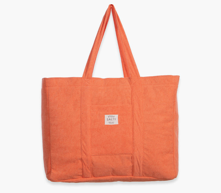 Πορτοκαλί τσάντα θαλάσσης μονόχρωμη με υφασμάτινες λαβές και εξωτερική τσέπη σε λευκό φόντο.