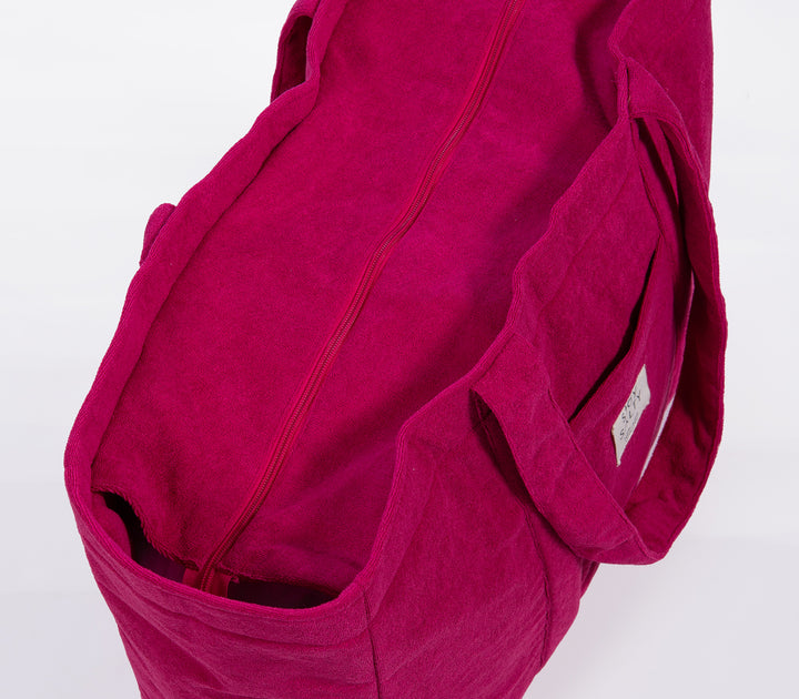 Κοντινό σε σαγκριά τσάντα θαλάσσης με φερμουάρ και μαλακή υφή υφάσματος σε ουδέτερο φόντο.