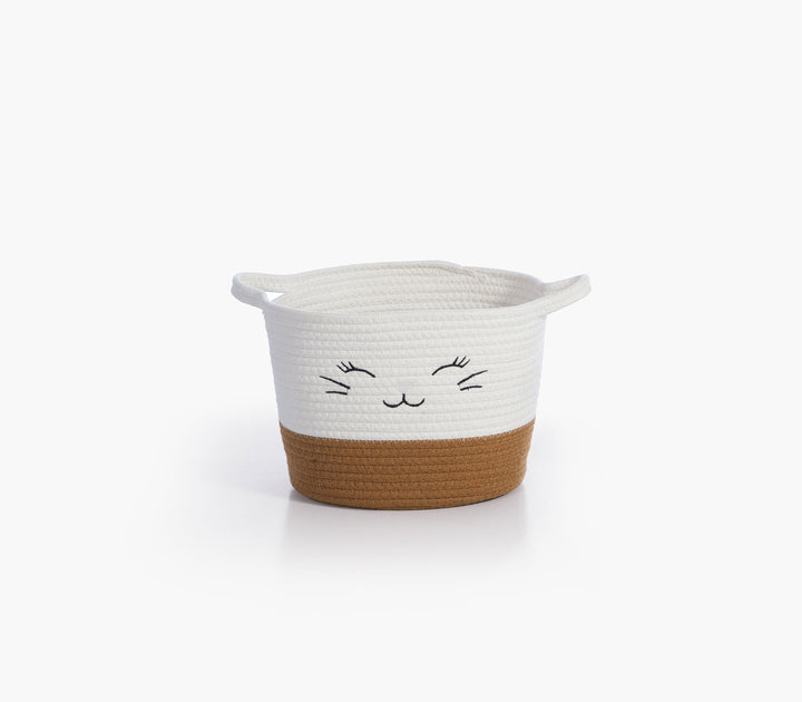 Μπεζ καλάθι αποθήκευσης Hilda της Nef-Nef Homeware από βαμβακερό σχοινί με κεντημένο χαμογελαστό πρόσωπο σε ουδέτερο φόντο.