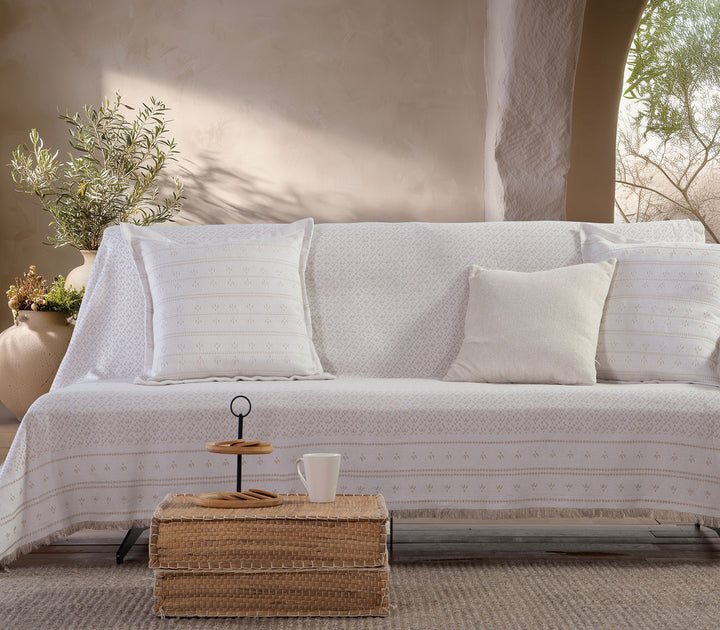 Μπεζ ριχτάρι Ishmar της Nef-Nef Homeware τοποθετημένο σε καναπέ με φυσική διακόσμηση και ζεστό φωτισμό χώρου.