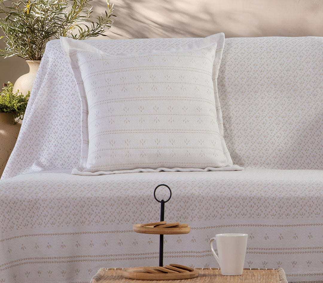 Ριχτάρι πολυθρόνας Ishmar της Nef-Nef Homeware σε μπεζ χρώμα απλωμένο σε καναπέ σαλονιού με διακοσμητικό μαξιλάρι.