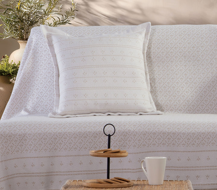 Μπεζ διακοσμητικό μαξιλάρι Ishmar της Nef-Nef Homeware τοποθετημένο σε καναπέ με ριχτάρι της ίδιας συλλογής.
