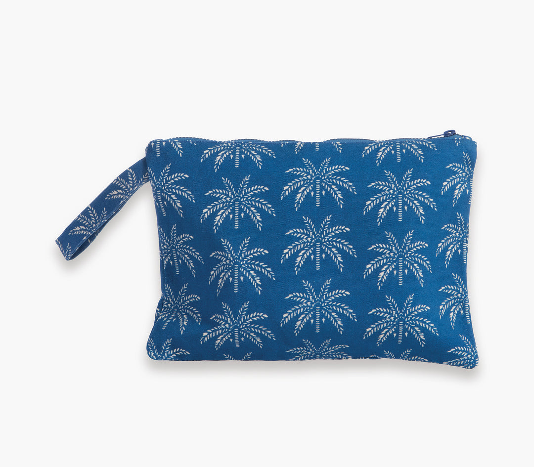 Τσαντάκι θαλάσσης σε μπλε χρώμα με λευκό μοτίβο φοίνικες και λουράκι χειρός σε λευκό φόντο.