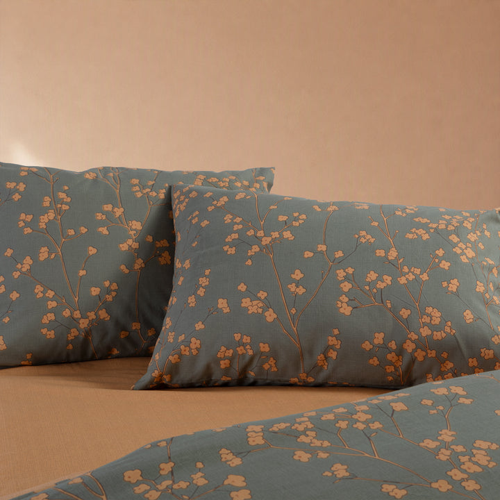 Κοντινή όψη πράσινης παπλωματοθήκης Floriva Nef-Nef Homeware με πορτοκαλί λουλουδάτο μοτίβο και μονόχρωμη πίσω όψη.
