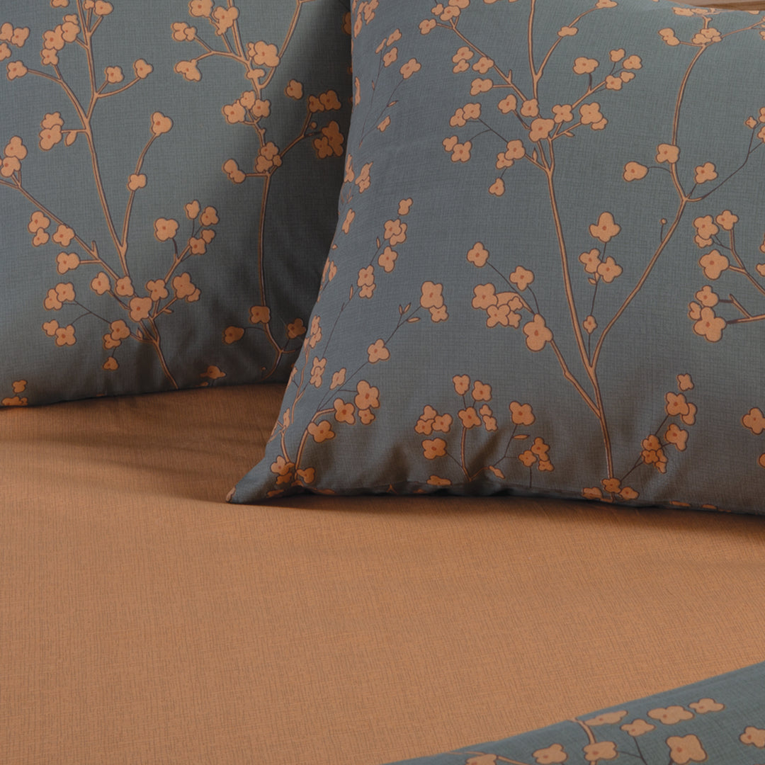Κοντινή όψη πράσινης παπλωματοθήκης Floriva Nef-Nef Homeware με πορτοκαλί λουλουδάτο μοτίβο και μονόχρωμη πίσω όψη.
